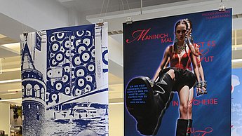 Foto von vier aufgehängten Plakaten, die alle im Blauton gehalten sind