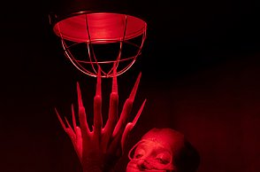 Eine kostümierte Frau posiert in rotem Licht