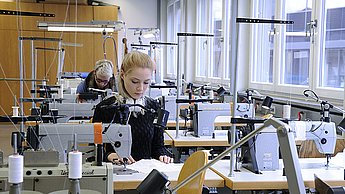 Studenten arbeiten mit Nähmaschinen 