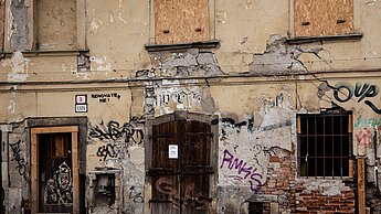 Verlassenes Gebäude mit Graffiti an der Fassade 