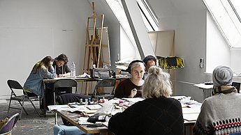 Studenten sitzen in einem Atelier 