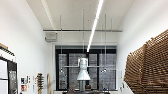 Foto eines Arbeitszimmer in welchem eine Modepuppe in der Mitte steht 