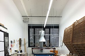 Foto eines Arbeitszimmer in welchem eine Modepuppe in der Mitte steht 