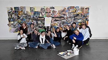 Gruppe posiert vor Wand mit aufgehängten Bildern