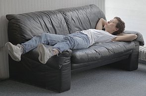 Ein Mann liegt entspannt auf einem Sofa