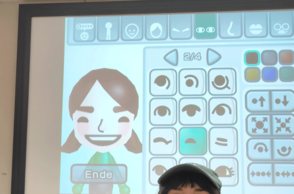Person steht vor einer Leinwand auf welcher ein Nintendo Mii Charakter von ihr erstellt wird