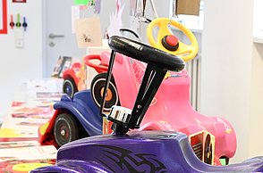 Foto eines modifizierten Bobbycars, welches lila mit schwarzen Stickern ist