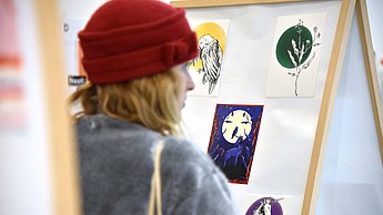 Person betrachtet aufgehängte Bilder