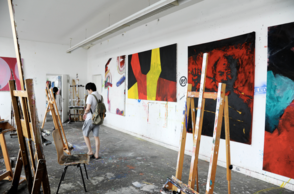 Atelier mit aufgehängten Gemälden und Staffeleien 