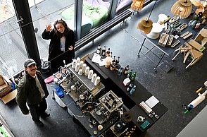 Foto einer Getränkebar an der zwei Personen stehen von oben