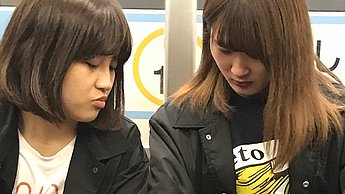 Zwei Frauen sitzen im Zug nebeneinander 