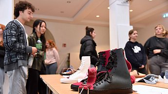 Personen betrachten ausgestellte Schuhdesigns