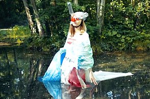 Eine Frau in einem Clownkostüm läuft durch einen See