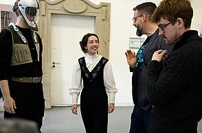 Foto von Personen die einen ausgestellten Sicherheitsanzug betrachten