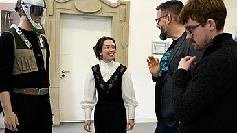 Foto von Personen die einen ausgestellten Sicherheitsanzug betrachten