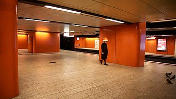 Foto eines Gangs mit orangenen Säulen