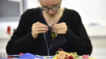 Studentin arbeitet mit Fäden