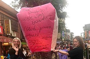 Drei Personen halten eine Laterne