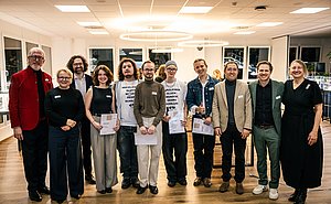 Gruppe von Menschen steht in einem Halbkreis zusammen für ein Gruppenfoto
