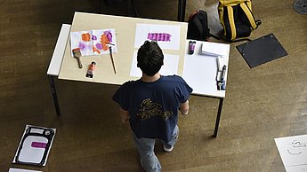 Student betrachtet Bilder auf einem Tisch