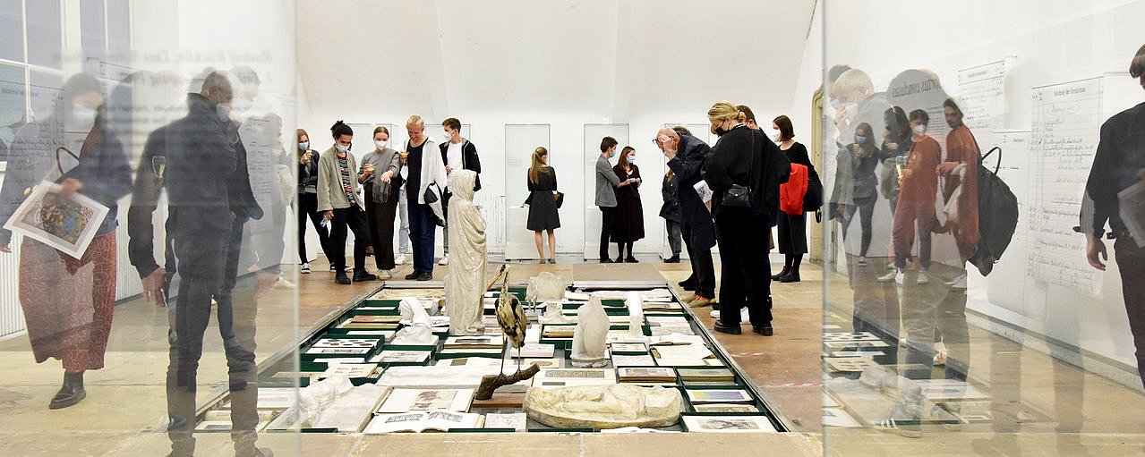 Eine Gruppe Menschen läuft um eine auf dem Boden liegende Ansammlung von Bildern