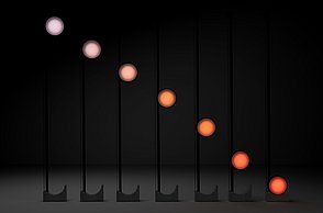 Dargestellt werden die unterschiedlichen Farbspektren der Leuchte – von kühlem, hellem Licht in der oberen Position über warmes Licht in der Mitte bis hin zu einem rötlichen Farbton unten, ähnlich einem Sonnenuntergang.