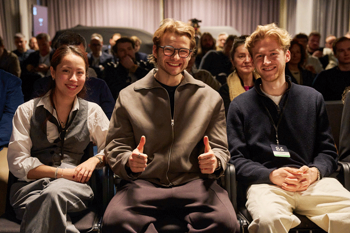 Foto von drei sitzenden Personen bei einer Veranstaltung