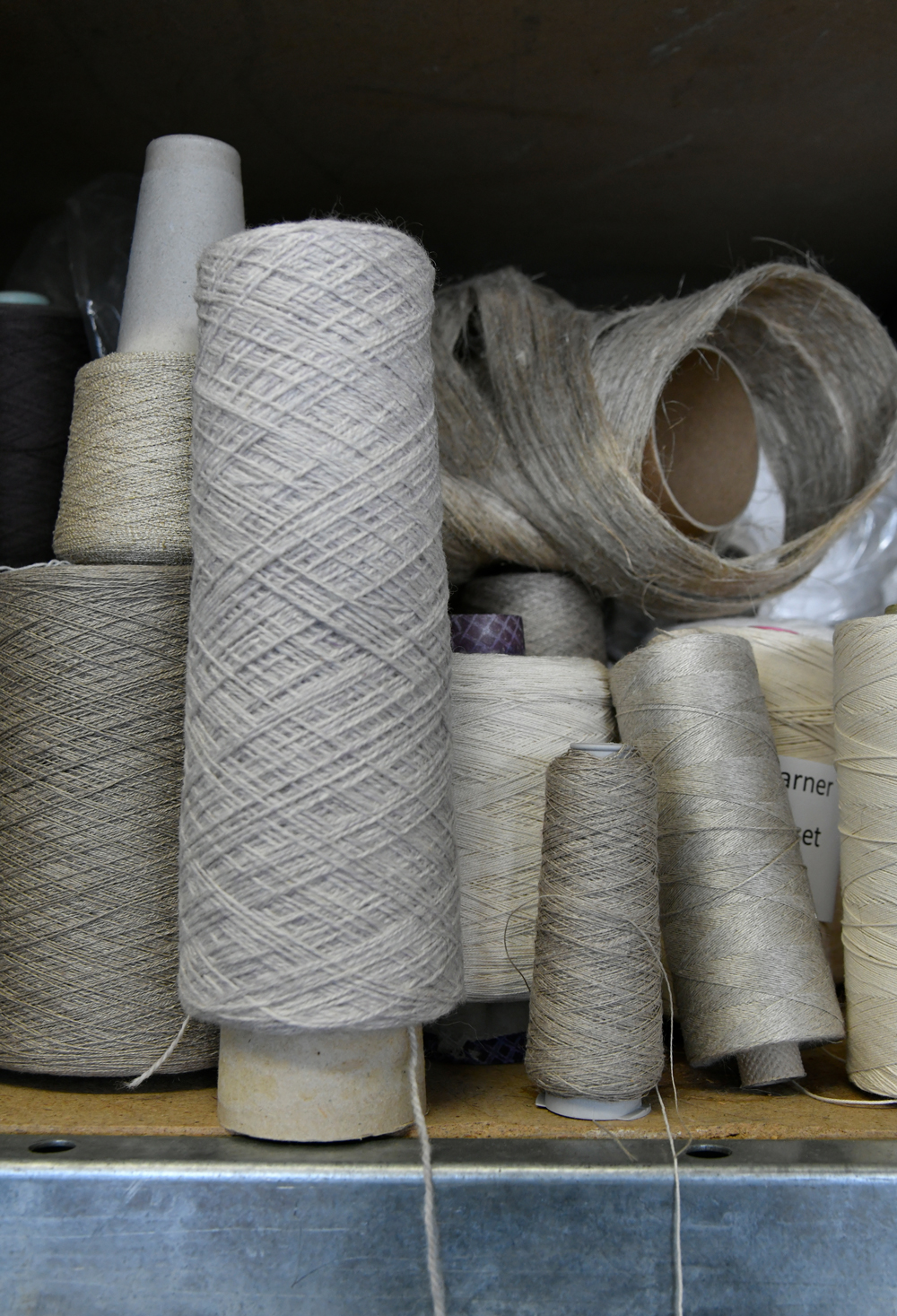 Ungefärbte Rollen von Garn im Regal